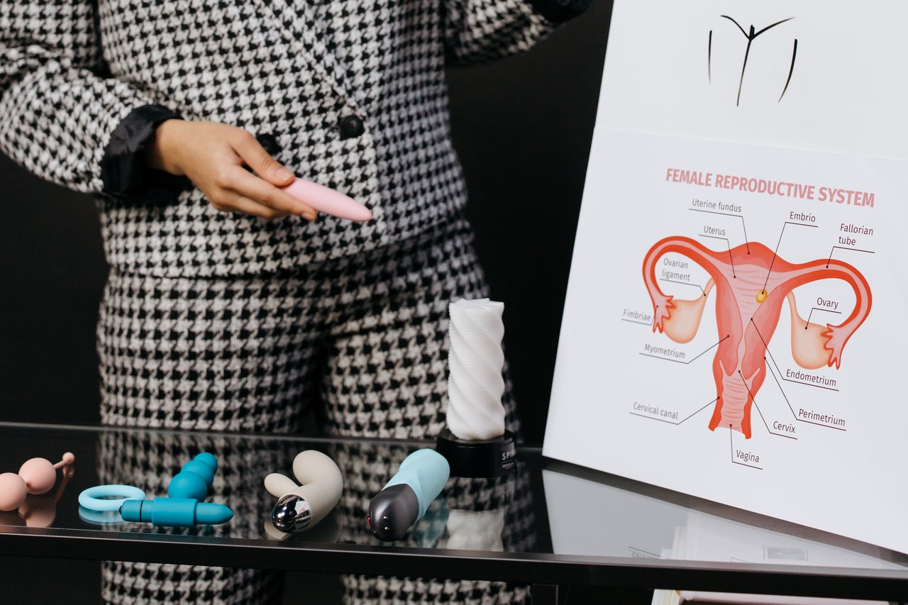 Mastering the First Impression: Your intriguing post title goes here A person demonstrates various sex toys alongside a female reproductive system diagram, emphasizing education.